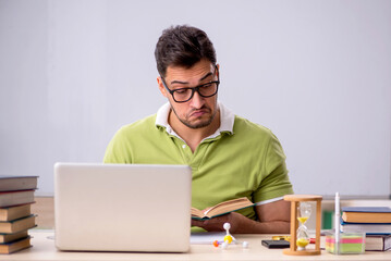 Young male student preparing for exams in the classroom