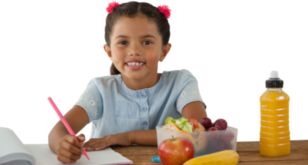 Girl writing in book at table