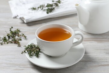 Obraz na płótnie Canvas Aromatic herbal tea with thyme on white wooden table
