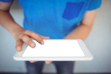 Schoolboy using digital tablet in corridor