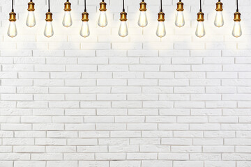 Many pendant lamps against white brick wall