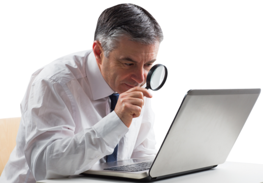 Mature businessman examining with magnifying glass