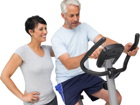 Happy woman looking at mature man on stationary bike - Powered by Adobe