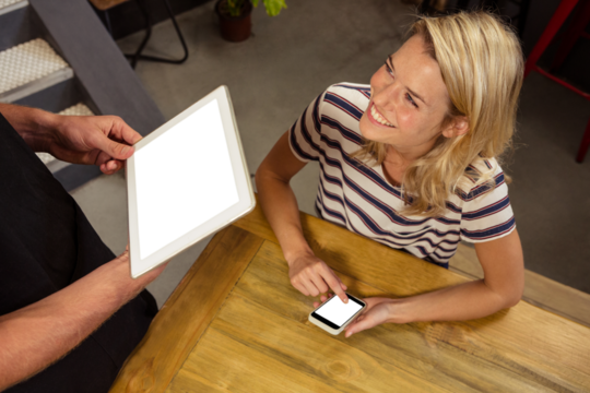 Woman looking at man holding digital tablet