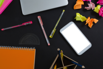 Laptop, mobile phone and stationery on black background