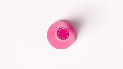 Laboratory flask with pink liquid. On a white, light background. View from above.