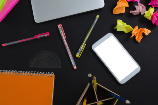 Laptop, mobile phone and stationery on black background