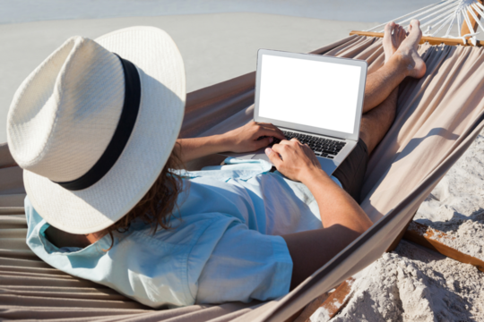 Man using laptop while relaxing on hammock