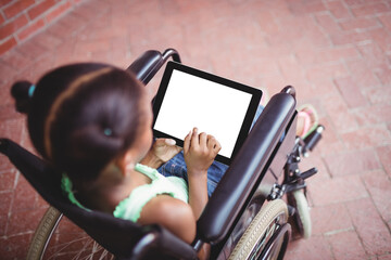 Young girl using digital computer sitting on wheelchair