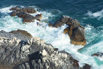 sea waves crash against the rocks
