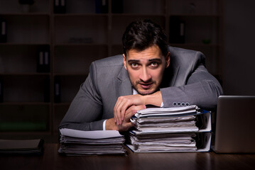 Young male employee working late in the office