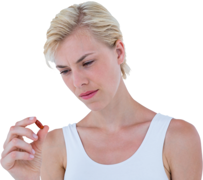 Concentrated blonde woman looking at red pill - Powered by Adobe