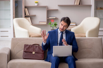 Fototapeta premium Young male employee working from home during pandemic