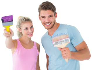 Young couple smiling and holding paintbrushes 