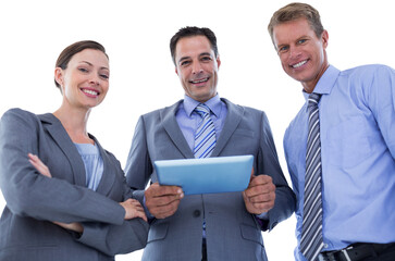 Business colleagues smiling at camera and holding tablet