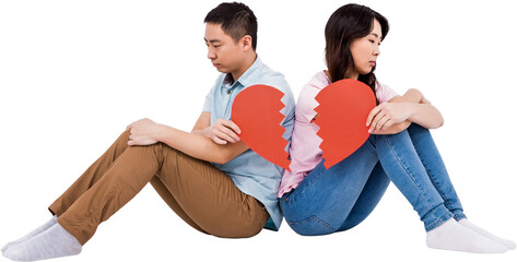 Sad couple holding broken heart pieces