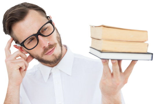 Geeky young man looking at pile of books