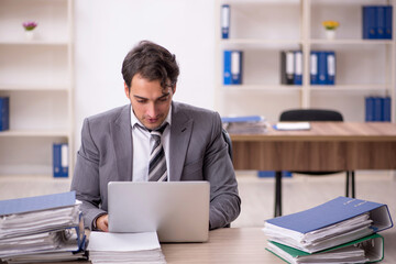 Young male employee unhappy with excessive work in the office