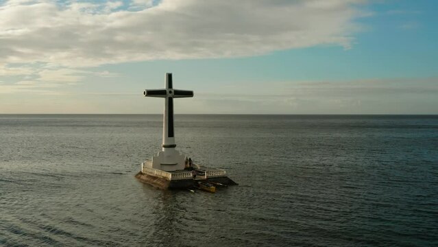 Catholic cross in sunken cemetery in the sea at sunset, aerial view. Sunset at Sunken Cemetery Camiguin Island Philippines.