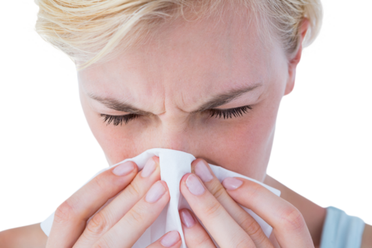 Close-up of attractive woman blowing her nose