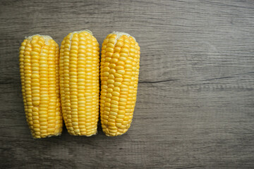Sweet corn cob pile on wooden table with copy space. Maize ears group, autumn sweetcorn, corncob...