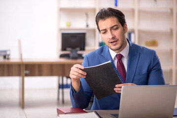 Young male employee and too much work in the office