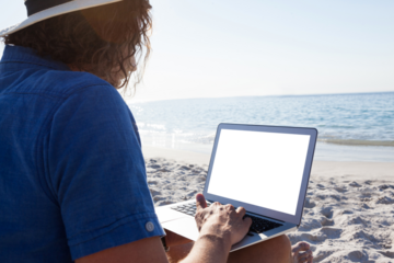 Man using laptop on the beach
