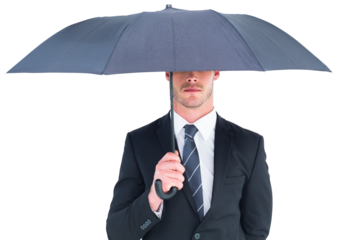 Unsmiling businessman sheltering under umbrella