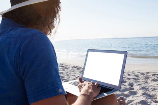 Man using laptop on the beach