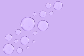 Large round drop of transparent cosmetic gel on a purple background.