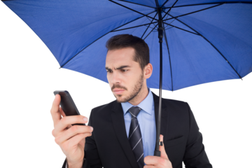 Concentrated businessman under umbrella using mobile