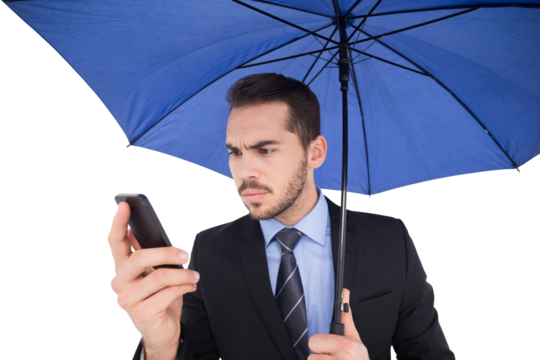 Concentrated businessman under umbrella using mobile - Powered by Adobe