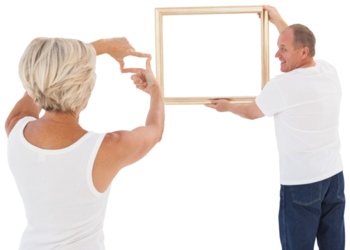 Mature couple hanging up picture frame