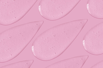 The background is cosmetic. Many smears of transparent gel on a pink background.
