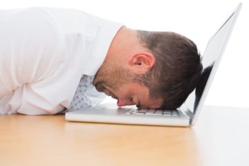 Tired businessman resting head on laptop