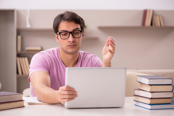 Young male student preparing for exams at home