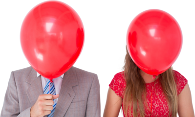 Geeky couple holding balloons in front of their faces