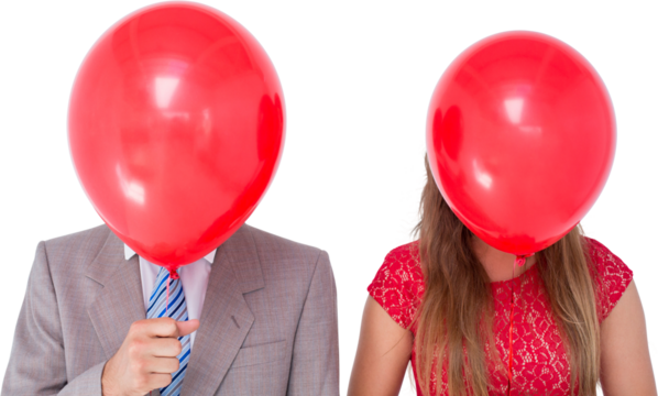 Geeky couple holding balloons in front of their faces 