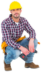 Crouching handyman holding power drill