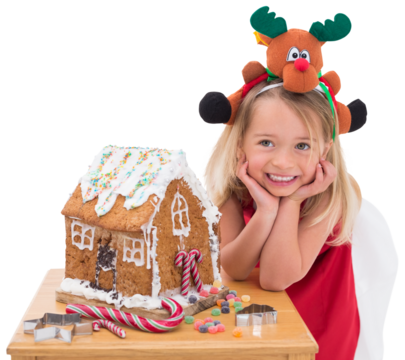 Festive little girl making gingerbread house - Powered by Adobe