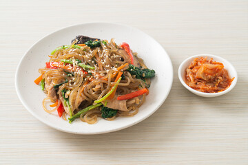 japchae or stir-fried Korean vermicelli noodles with vegetables and pork topped with white sesame
