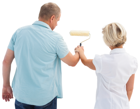 Happy older couple painting white wall