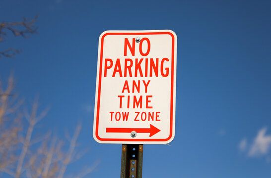 No parking signs symbolize restricted parking zones to ensure safety, access, or traffic flow. They communicate that vehicles must not stop, stand, or park in the designated area.