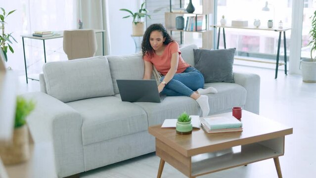 Home laptop, sofa and woman reading, relax or working on freelance remote work on apartment living room couch. Internet, web or person doing review of website, article story or social media blog post