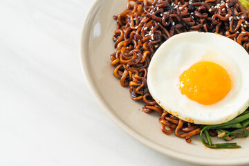 dried Korean spicy black sauce instant noodles with fried egg and kimchi