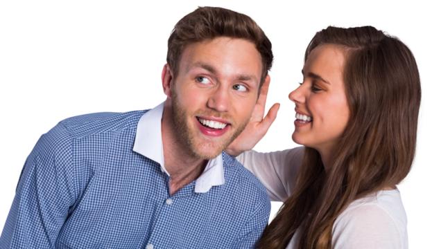 Happy young woman whispering secret into friends ear