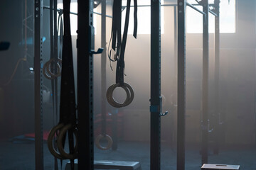 Traditional wooden gymnast rings hanging in the gym against sunlight coming through the window