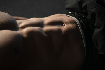 Close-u view on a handsome fit sporty man's chest does abdominal exercises in the gym for abs...