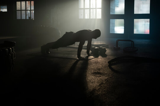 Male athlete doing push-up exercise and lifting body with arms on the floor for muscle build up
