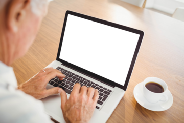 Focused elderly man typing on laptop